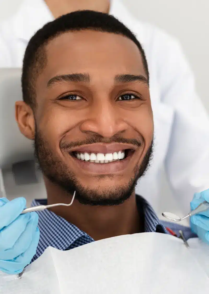 A patient smiling after receiving their routine dental exam.